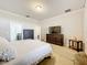 Spacious bedroom with a queen-sized bed, dresser, and large TV for ultimate comfort and entertainment at 22004 Belgian Ct, Mount Dora, FL 32757