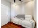 A bedroom with hardwood floors, a white loveseat with consoles and cup holders, and a white door is shown at 22004 Belgian Ct, Mount Dora, FL 32757
