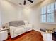 Bright room with wood floors, plantation shutters, and a white leather loveseat with built in consoles and cup holders at 22004 Belgian Ct, Mount Dora, FL 32757
