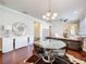 Open dining room boasts a modern chandelier, elegant mirror, and hardwood flooring next to the living room at 22004 Belgian Ct, Mount Dora, FL 32757