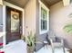 Cozy front porch with a decorative glass front door, planter, and neutral decor, offering curb appeal at 22004 Belgian Ct, Mount Dora, FL 32757