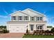 Two-story house with a white and gray exterior, a three-car garage, and a well-manicured lawn at 366 Hammock Oaks Blvd, Lady Lake, FL 32159