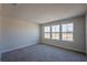 Bedroom features carpet flooring, neutral walls, and a row of windows overlooking an open field at 633 Highfalls Ave, Debary, FL 32713