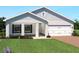 Inviting single-Gathering home with manicured lawn, charming shutters, and attached two-car garage at 1412 Laramie Way, Haines City, FL 33844