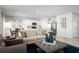 Bright living room with modern decor, neutral tones, and an open layout with the kitchen in the background at 1412 Laramie Way, Haines City, FL 33844