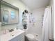 Bathroom featuring a sleek mirror, floating shelves and modern sink, complemented by a shower with white tiles at 1531 Ne 38Th St, Ocala, FL 34479