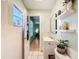 Bathroom featuring a sleek mirror, floating shelves and modern sink, complemented by tiled flooring at 1531 Ne 38Th St, Ocala, FL 34479