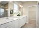 Bright bathroom boasts dual vanities with white countertops, ample lighting, and a walk-in shower at 1628 Covey Rise Ter, Winter Haven, FL 33884