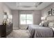 Serene bedroom showcasing a tray ceiling, large window, and elegant furnishings at 1632 Covey Rise Ter, Winter Haven, FL 33884