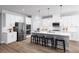 Modern kitchen featuring white cabinets, stainless steel appliances, an island with seating, and hardwood floors at 1632 Covey Rise Ter, Winter Haven, FL 33884