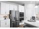 Bright kitchen featuring stainless steel refrigerator and double oven, white cabinets, and a spacious countertop at 1632 Covey Rise Ter, Winter Haven, FL 33884