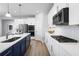 Modern kitchen boasts navy blue and white cabinets, stainless steel appliances, quartz countertops, and a gas stove at 1632 Covey Rise Ter, Winter Haven, FL 33884