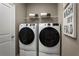 Well-equipped laundry room with a modern washer and dryer set and shelving for storage at 1632 Covey Rise Ter, Winter Haven, FL 33884