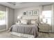 Serene main bedroom featuring a tray ceiling, neutral tones, plush bedding, and abundant natural light at 1632 Covey Rise Ter, Winter Haven, FL 33884