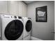 Laundry room featuring modern appliances, overhead cabinets, and a stylish 'FOLD' sign at 1636 Covey Rise Ter, Winter Haven, FL 33884