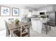 Modern kitchen with stainless steel appliances, granite countertops, bar seating and an adjacent dining area at 2152 Tennessee St, Sumterville, FL 33585