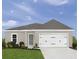 Charming single Gathering home showcasing a well-manicured lawn and a two car garage at 2183 Oklahoma Dr, Sumterville, FL 33585