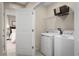 Functional laundry room equipped with a washer, dryer, and shelving, conveniently located near a bedroom at 2183 Oklahoma Dr, Sumterville, FL 33585