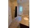 Bathroom features a shower with glass door, a window and earth tone tile floors at 600 Se 52Nd Ave, Ocala, FL 34471