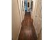 A hallway featuring wood-look floors and neutral walls, adorned with framed artwork at 600 Se 52Nd Ave, Ocala, FL 34471
