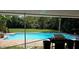 Outdoor pool area with a barbecue grill and surrounded by lush greenery offering a private backyard at 600 Se 52Nd Ave, Ocala, FL 34471