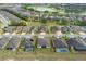 Wide aerial view of a neighborhood with lush greenery, showcasing a pond and well-maintained homes at 9773 Sw 63Rd Loop, Ocala, FL 34481