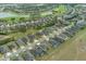 Wide aerial view of a residential area near a golf course and pond, showcasing uniform rooftops and green spaces at 9773 Sw 63Rd Loop, Ocala, FL 34481
