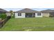 Large green backyard features a screened-in porch and a white exterior paint on the home at 9773 Sw 63Rd Loop, Ocala, FL 34481