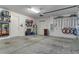Spacious two car garage with wall shelving, tool organization, and painted concrete flooring at 9773 Sw 63Rd Loop, Ocala, FL 34481