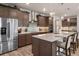 Open kitchen with a large island, stainless steel refrigerator, custom cabinets, and modern lighting fixtures at 9773 Sw 63Rd Loop, Ocala, FL 34481
