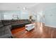 Open-concept living room showcases hardwood floors, pale blue walls, a gray sectional sofa, and a view into the dining area at 10542 Cr 671, Bushnell, FL 33513