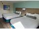 Hotel bedroom featuring two beds, cool-toned decor, and overhead lighting at 3000 Maingate Ln # 420, Kissimmee, FL 34747