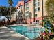 Exterior shot of Galleria hotel pool with palm trees and chaise lounges at 3000 Maingate Ln # 420, Kissimmee, FL 34747