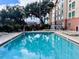 Inviting in-ground swimming pool surrounded by lush greenery at 3000 Maingate Ln # 420, Kissimmee, FL 34747