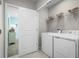 Convenient laundry room with washer, dryer, shelving, and easy access to a bedroom, offering functionality and style at 1180 Ivy Manor St, Minneola, FL 34715