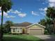 Charming single-story home boasts a manicured lawn and elegant landscaping at 1262 Whispering Ln, Minneola, FL 34715