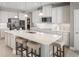 Modern kitchen with white cabinets, stainless steel appliances, large island, and pendant lighting above the counter at 1309 Whispering Ln, Minneola, FL 34715