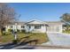 Charming single-story home with a well-manicured lawn, screened-in garage, and beautiful landscaping at 17975 Se 106Th Ct, Summerfield, FL 34491