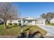 Charming single-story home with a well-manicured lawn, screened-in garage, and beautiful landscaping at 17975 Se 106Th Ct, Summerfield, FL 34491