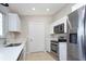 Well-lit kitchen with stainless steel appliances, quartz countertops, tile flooring, and crisp white cabinetry at 17975 Se 106Th Ct, Summerfield, FL 34491