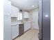 Modern kitchen featuring stainless steel appliances, white cabinetry, tile flooring, and bright lighting at 17975 Se 106Th Ct, Summerfield, FL 34491