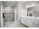 Modern bathroom featuring double sinks, tiled floors, and a glass-enclosed shower at 1314 Whispering Ln, Minneola, FL 34715