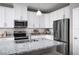 Modern kitchen with stainless steel appliances, granite countertops, and ample cabinet space at 1314 Whispering Ln, Minneola, FL 34715
