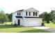Charming two-story home with white siding, a two-car garage, and a well-manicured lawn at 5039 Bear Lake Loop, Deland, FL 32724