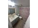Bright bathroom features a gray vanity, illuminated mirror, toilet, and shower with pink floral shower curtain at 722 E Michigan St # 145, Orlando, FL 32806