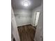 Walk-in closet featuring wire shelving, neutral walls, new flooring, and a white door at 722 E Michigan St # 145, Orlando, FL 32806
