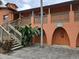 Condominium building with orange walls, stairs to the units, and tropical foliage at 722 E Michigan St # 145, Orlando, FL 32806