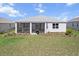 Home featuring a screened-in patio and well-kept backyard with grass and landscaping at 8750 Sw 79Th Loop, Ocala, FL 34481