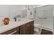 Bathroom featuring a quartz countertop, dark cabinets, and walk-in shower at 8750 Sw 79Th Loop, Ocala, FL 34481