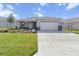 Charming single-story home featuring a well-manicured lawn, a two-car garage, and a welcoming front porch at 8750 Sw 79Th Loop, Ocala, FL 34481